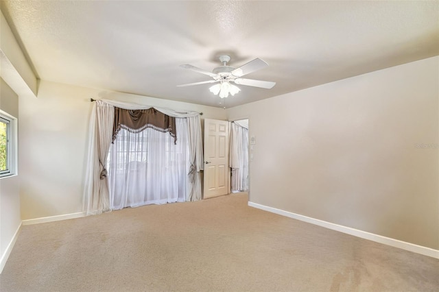 spare room featuring ceiling fan and carpet