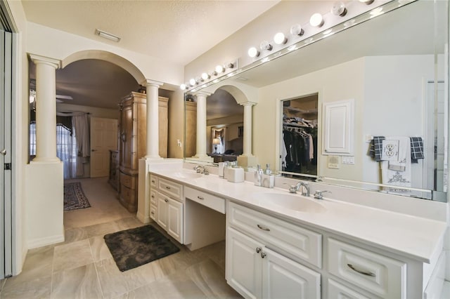 bathroom featuring vanity, a textured ceiling, and ornate columns