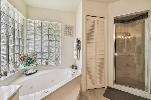 bathroom featuring vanity, hardwood / wood-style flooring, and plus walk in shower