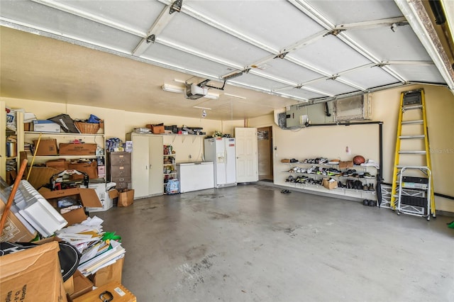 garage with a garage door opener and white refrigerator with ice dispenser