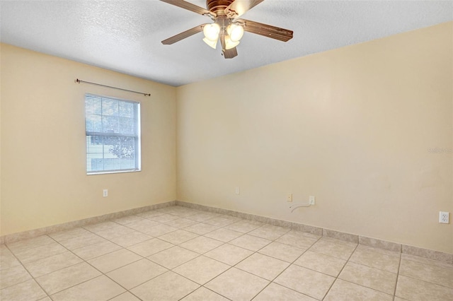 unfurnished room with ceiling fan, a textured ceiling, and light tile patterned floors