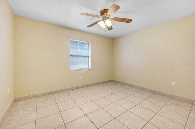 tiled empty room featuring a textured ceiling and ceiling fan