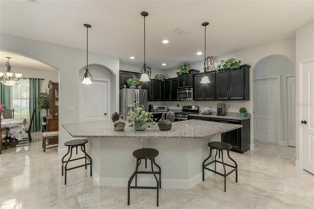 619 Meadow Sage Dr, Deland, FL 32724 - kitchen with light stone counters, a center island with sink, a breakfast bar, and appliances with stainless steel finishes