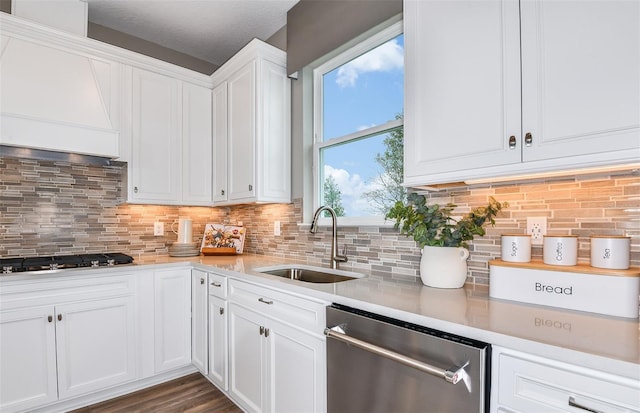 kitchen with white cabinetry, sink, backsplash, and dishwasher