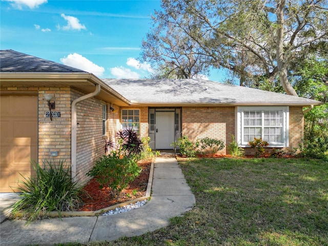 entrance to property featuring a yard and a garage