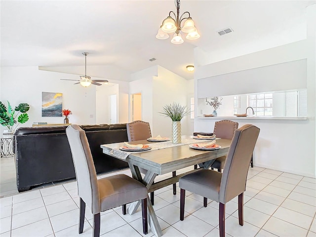 tiled dining space with ceiling fan with notable chandelier and vaulted ceiling