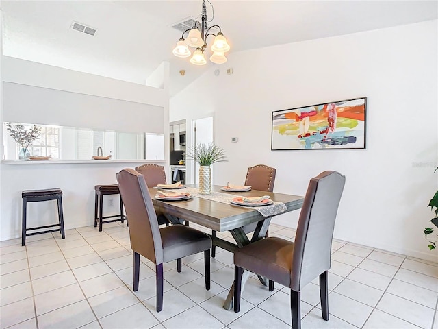 tiled dining room with lofted ceiling and an inviting chandelier