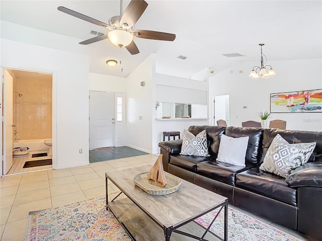 living room with ceiling fan with notable chandelier, lofted ceiling, and light tile patterned floors