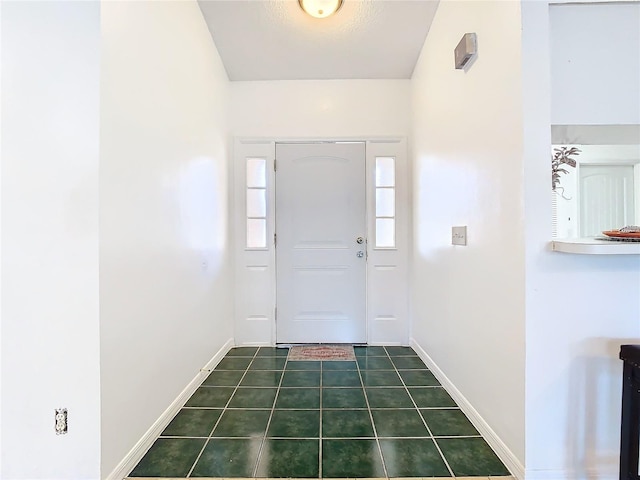 foyer featuring dark tile patterned flooring