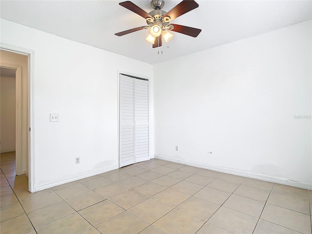 unfurnished bedroom featuring light tile patterned floors, a closet, and ceiling fan