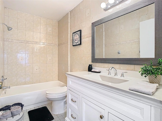 full bathroom with toilet, tile walls, vanity, tiled shower / bath combo, and tile patterned flooring