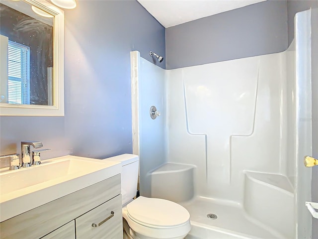 bathroom featuring vanity, toilet, and walk in shower