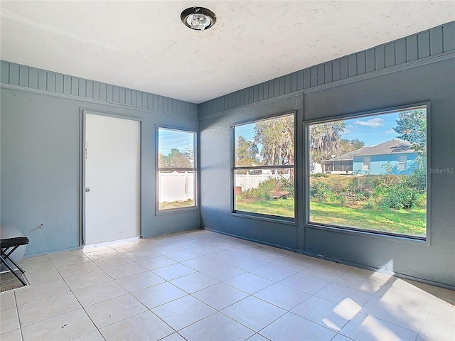 tiled spare room with a textured ceiling