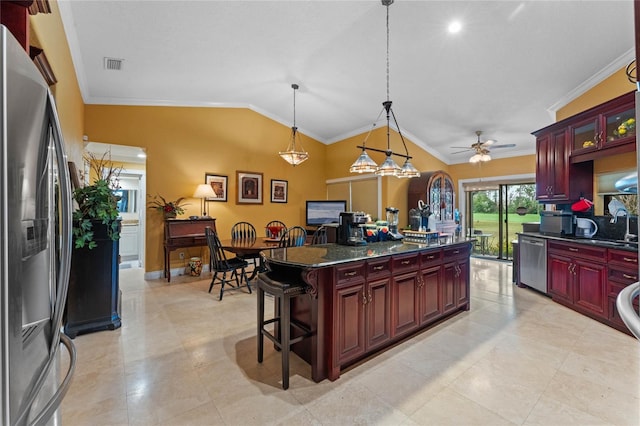 kitchen with a kitchen island, appliances with stainless steel finishes, lofted ceiling, a kitchen breakfast bar, and hanging light fixtures