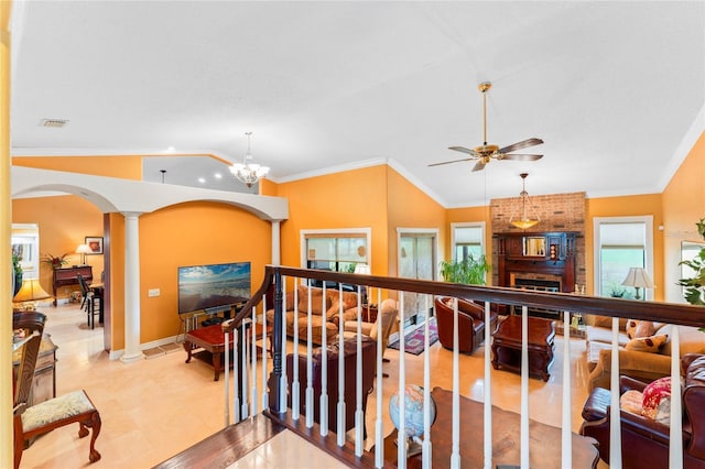 hall featuring crown molding, a notable chandelier, vaulted ceiling, and ornate columns