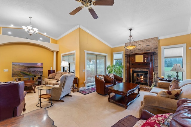 living room with crown molding, lofted ceiling, a fireplace, and ceiling fan with notable chandelier