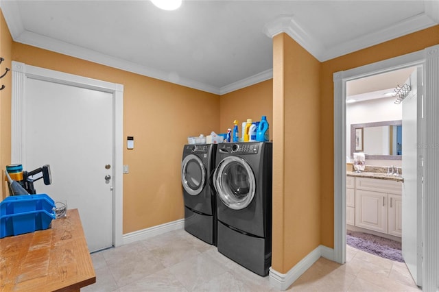 clothes washing area featuring washing machine and clothes dryer, ornamental molding, sink, and light tile patterned floors