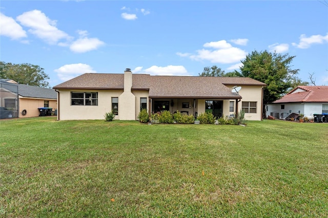 rear view of house featuring a yard