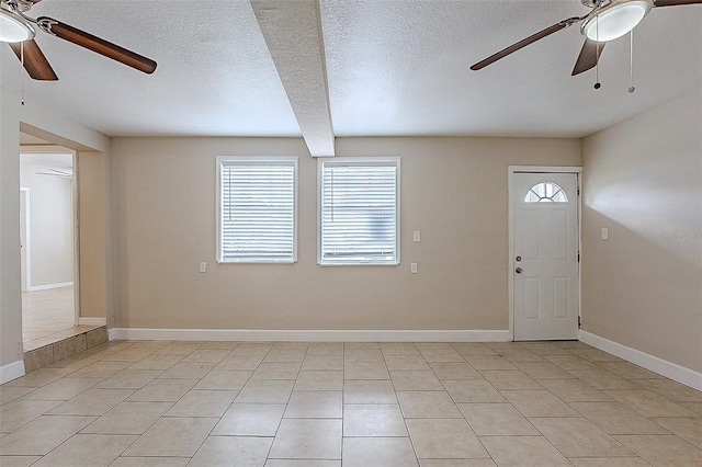 foyer with light tile patterned floors, a textured ceiling, a ceiling fan, and baseboards