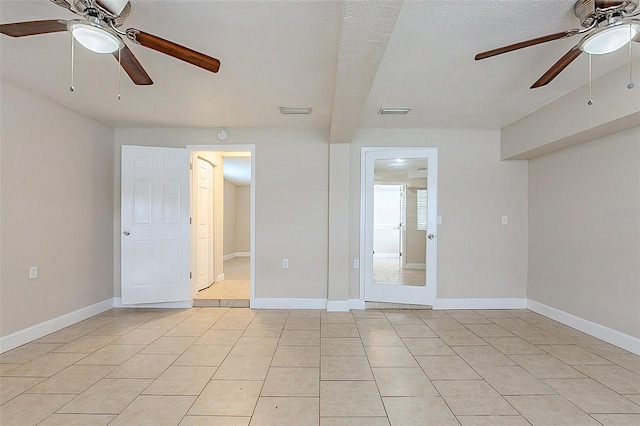 spare room featuring light tile patterned flooring, visible vents, and baseboards