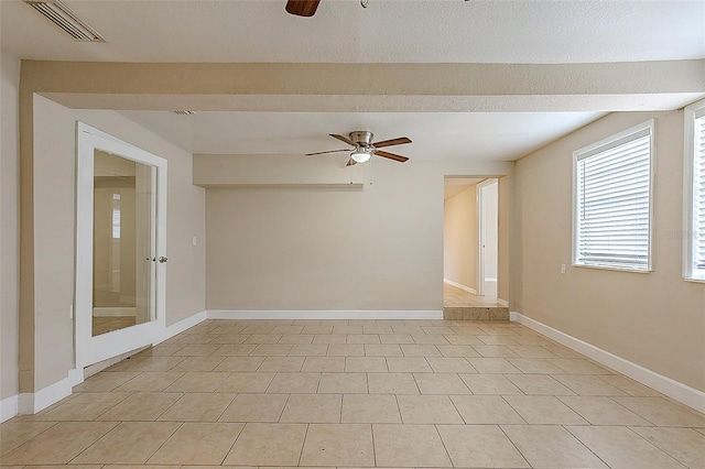 empty room with baseboards, visible vents, and a ceiling fan