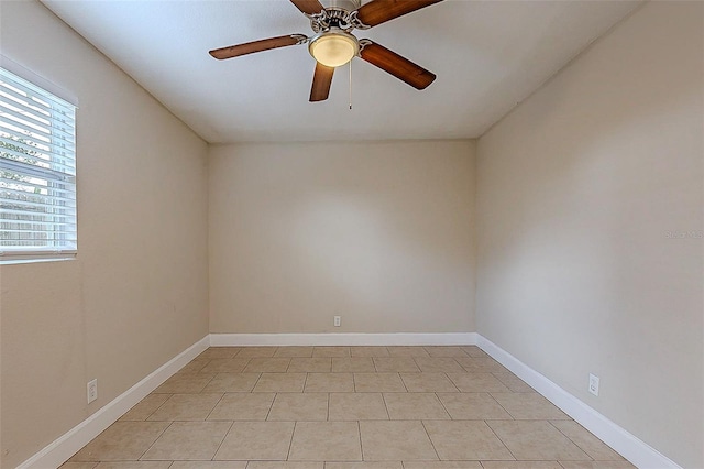 spare room featuring ceiling fan and baseboards