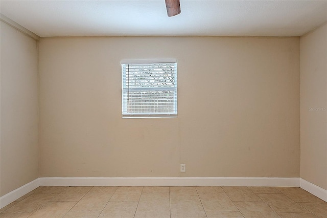 spare room featuring light tile patterned floors and baseboards