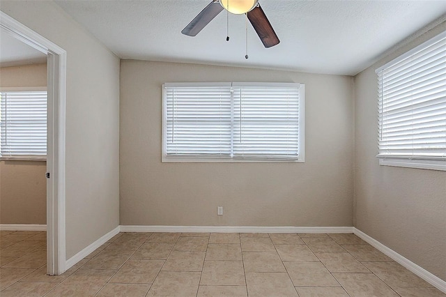 spare room featuring a ceiling fan, baseboards, and light tile patterned floors