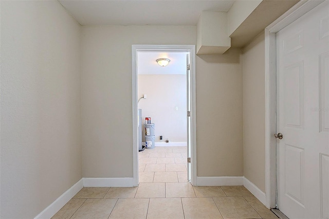 corridor featuring light tile patterned floors and baseboards