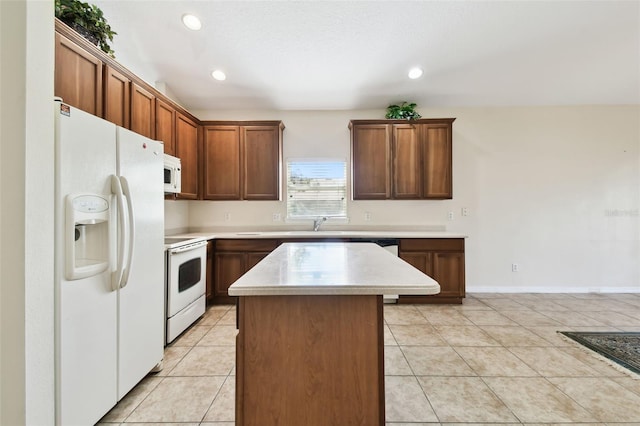 kitchen featuring white appliances, a center island, and light tile patterned floors