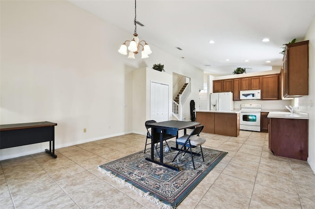 dining area featuring sink, hanging light fixtures, high vaulted ceiling, a center island, and light tile patterned flooring