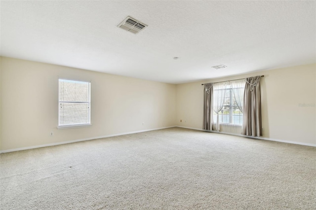 carpeted empty room featuring a textured ceiling