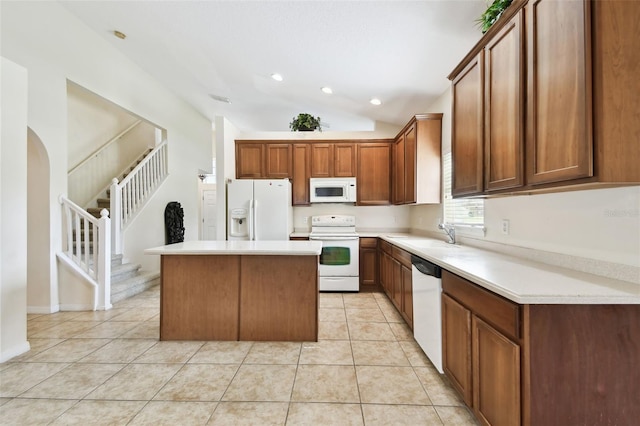 kitchen featuring lofted ceiling, sink, a center island, light tile patterned floors, and white appliances