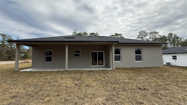 rear view of property with a patio and a lawn