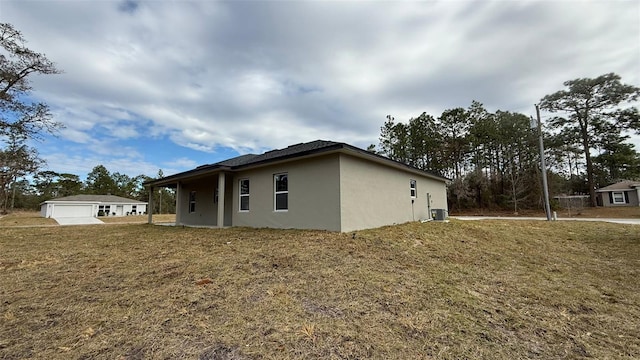 view of home's exterior featuring a garage, an outdoor structure, and a lawn