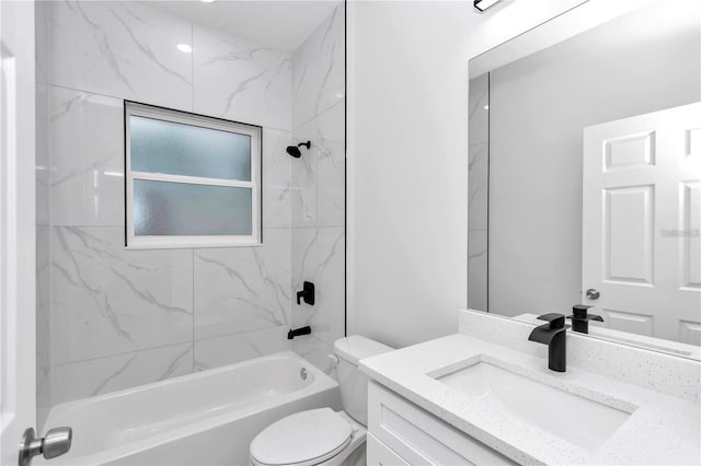 full bathroom featuring vanity, tiled shower / bath combo, and toilet