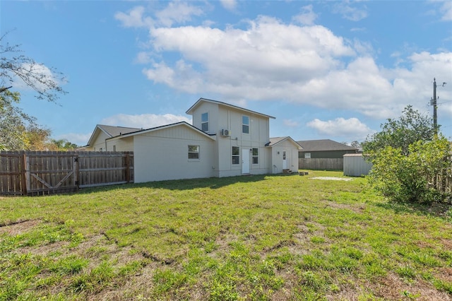 rear view of house featuring a fenced backyard and a lawn