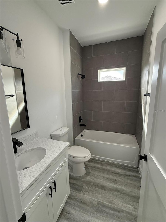 bathroom with shower / tub combination, toilet, vanity, and wood finished floors