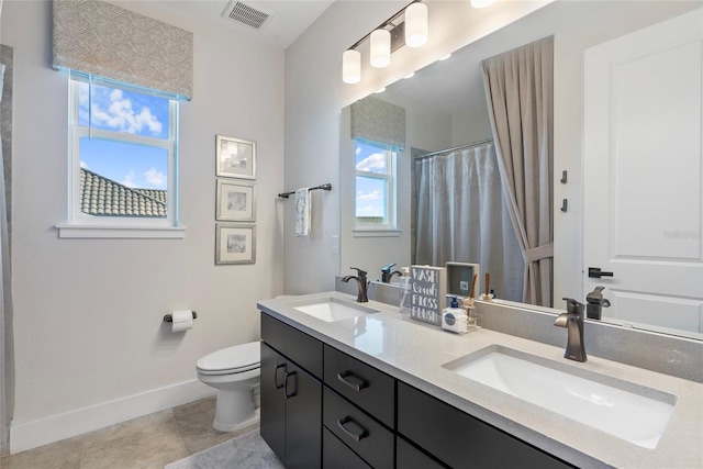 bathroom featuring double vanity, a sink, visible vents, and baseboards