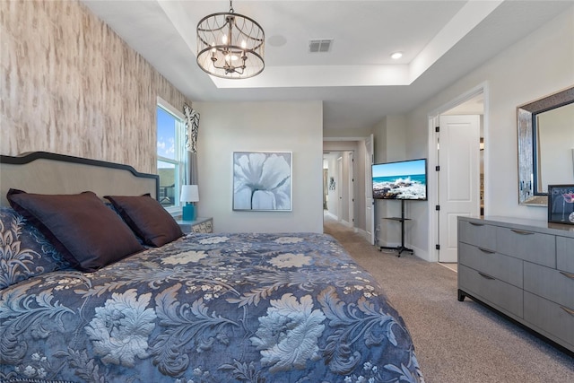 bedroom with a notable chandelier, light carpet, visible vents, baseboards, and a raised ceiling