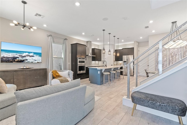 living area featuring a chandelier, recessed lighting, and visible vents