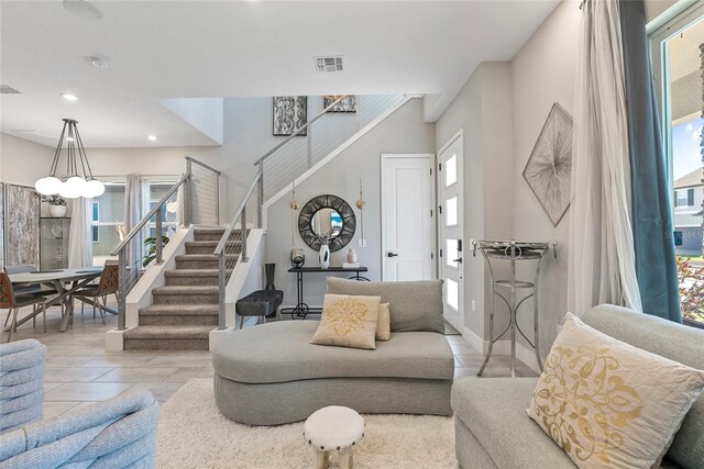 living area featuring a wealth of natural light, stairway, and visible vents