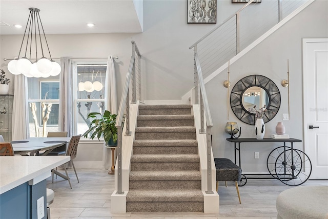 stairway featuring baseboards, wood finish floors, and recessed lighting