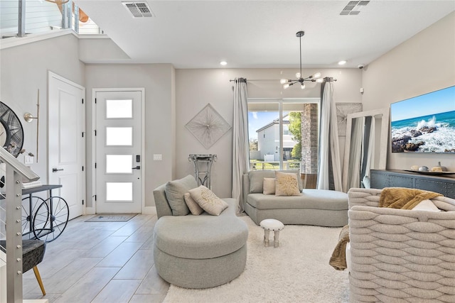 living area featuring recessed lighting, visible vents, and an inviting chandelier