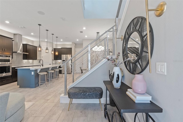 stairway with wood finished floors and recessed lighting