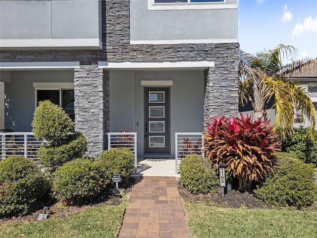 property entrance featuring stone siding and stucco siding