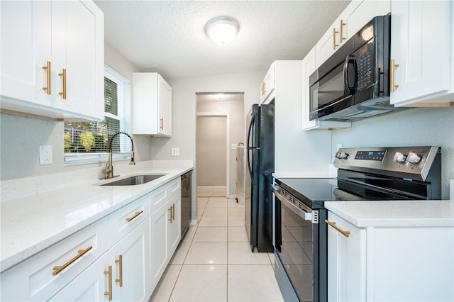 kitchen featuring light tile patterned floors, sink, light stone counters, white cabinetry, and black appliances