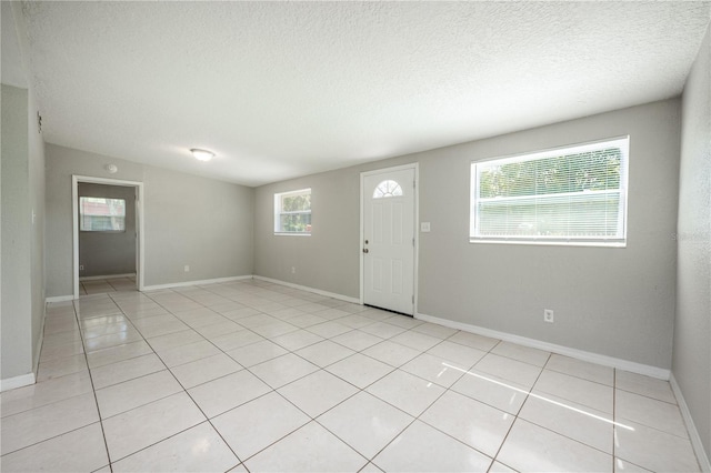 interior space featuring light tile patterned floors and a textured ceiling