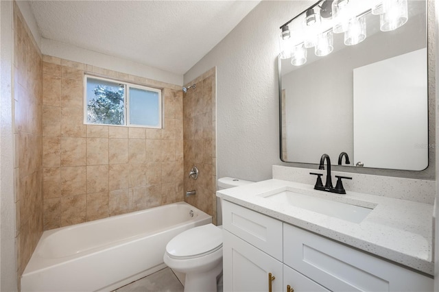 full bathroom featuring a textured ceiling, toilet, vanity, and tiled shower / bath