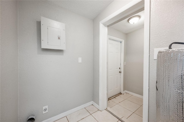 washroom with a textured ceiling, electric panel, electric dryer hookup, and light tile patterned floors